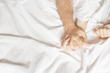 Şehvetli güzel genç çift yatakta seks yapıyor. Ecstasy, orgazm beyaz çarşaf çekerek el. Aşk kavramı. Sağlık. İki aşık. Orgazm kavramı
