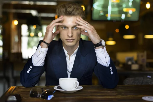 Worried man in cafe. Coffee cup on the table