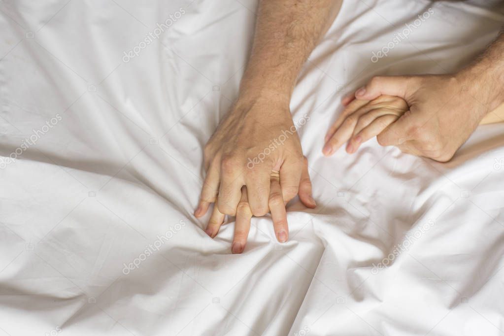 couple hands pulling white sheets in ecstasy, orgasm. Concept of passion. Oorgasm. Erotic moments. Intimate concept. Sex couple. Bedroom. Hotel room. Spa. Vacation