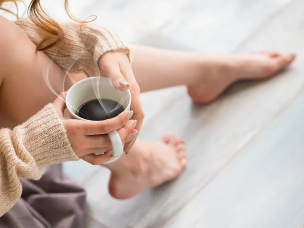 Pies femeninos y una taza de café — Foto de Stock