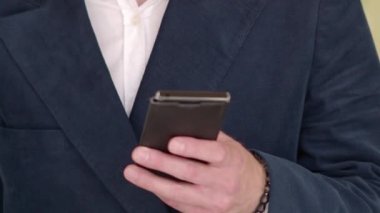 - Telefon. İş adamı, şehrin iş bölgesindeki akıllı telefonlarda uygulamayla mesajlaşma kullanıyor. Genç işadamı cep telefonunu açık havada takım elbiseli mutlu bir şekilde kullanıyor. Kentsel erkek profesyonel.