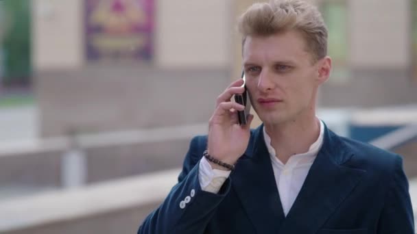 屋外の電話で話している若い物思いにふけるビジネスマン — ストック動画