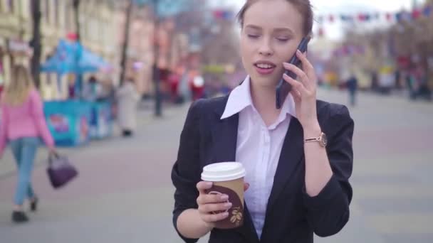 年轻成功的女商人使用智能手机在市中心 职业女性雇主与商业伙伴交谈喝咖啡 商业区摩天大楼背景 — 图库视频影像