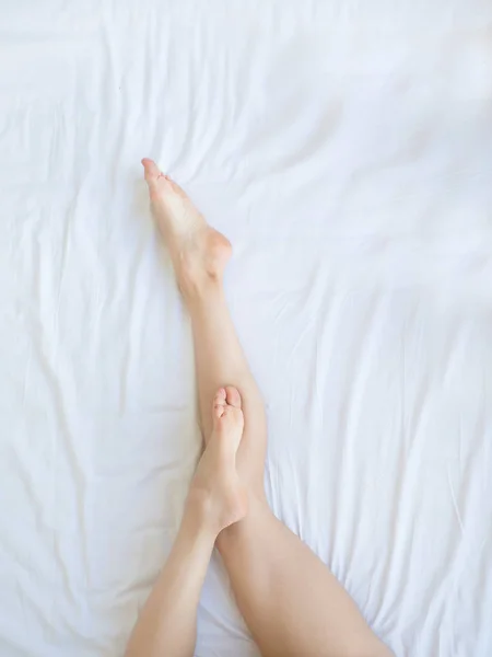 화이트에 근접 촬영 여자 다리 침대, 아름다움과 피부 관리 개념. — 스톡 사진