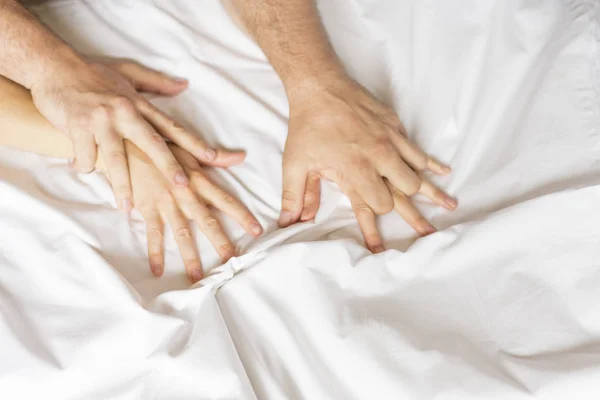 Close up hands of a couple having sex on a bed — Stock Photo, Image