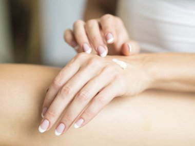 Kadın krem ellerinin üzerinde geçerlidir. Yakın çekim.