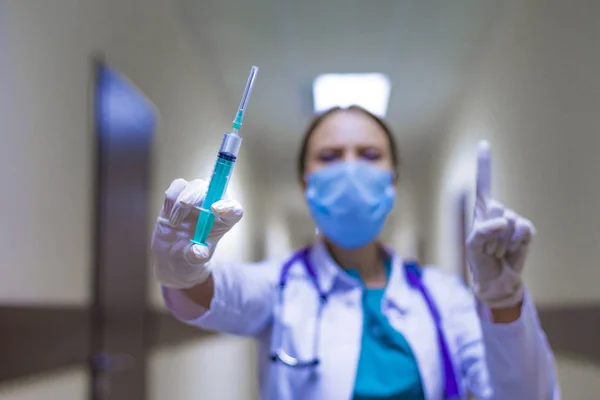 Young Female Doctor Holding Syringe Hospital Corridor Showing Attention Sign — Stock Photo, Image