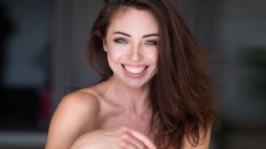 yakın çekim portre çekici bir genç kadın gülümsüyor.