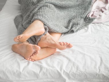 Yataktaki bir çiftin ayaklarına yakın çekim..