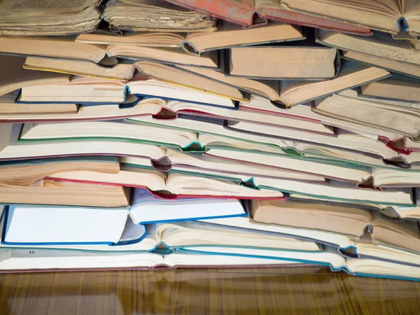 Een heleboel geopende oude en gebruikte hardback boeken of studieboeken. Boek en het lezen zijn essentieel voor zelfverbetering, verkrijgen van kennis en succes in onze carrière, zakelijke en persoonlijke leven — Stockfoto