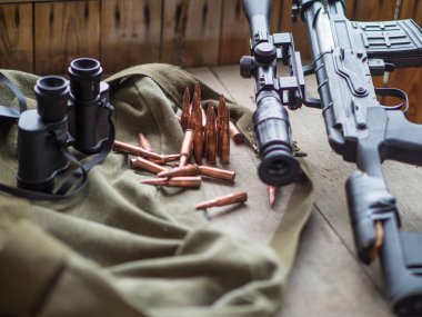 Keskin nişancı tüfeği, bunoculars ve cephane üzerinde ahşap zemin döşeme