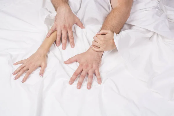 Close up of passionate couple hold hands during making intense love in bedroom, lovers enjoy hot sex on white sheet, boyfriend and girlfriend relax having intimacy at home, reaching orgasm or ecstasy — Stock Photo, Image