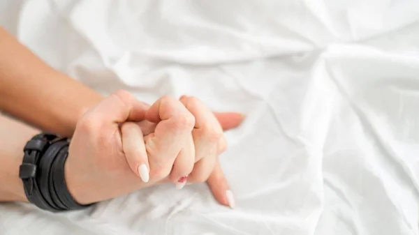 Sensuel beau jeune couple fait l'amour sur le lit. Main féminine tirant des draps blancs en extase, orgasme. Concept d'amour. Bien-être. Couple amoureux. Concept d'orgasme . — Photo