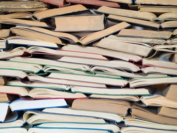 Een heleboel geopende oude en gebruikte hardback boeken of studieboeken. Boek en het lezen zijn essentieel voor zelfverbetering, verkrijgen van kennis en succes in onze carrière, zakelijke en persoonlijke leven — Stockfoto