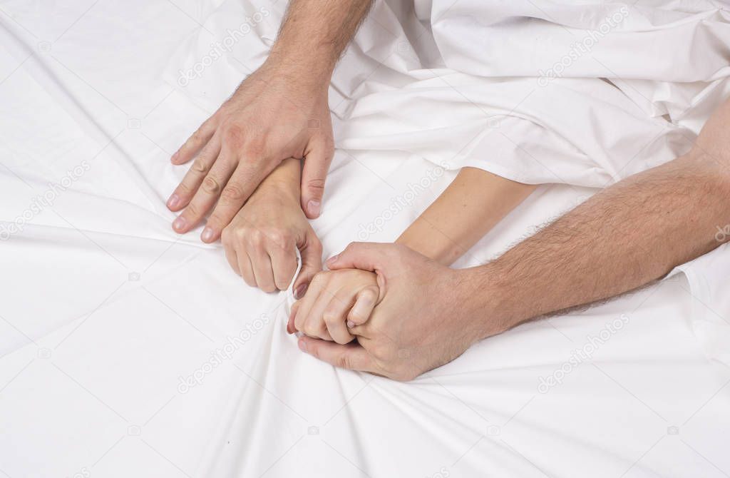 Close up hands of a couple make love hot sex on a bed