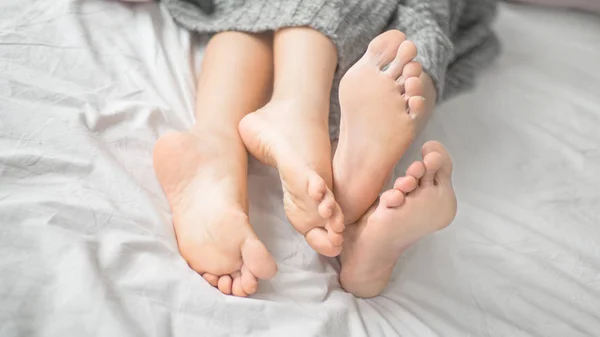 朝の寝室で白いベッドの上のカップル恋人睡眠の裸足の足を閉じる — ストック写真
