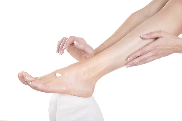 Жінка наносить крем на її голі ноги — стокове фото