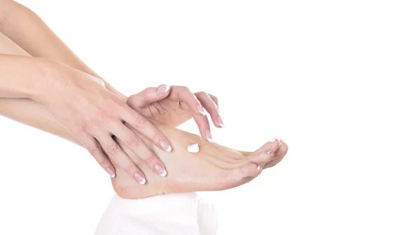 Жіночі руки і ноги крупним планом. жінка наносить зволожуючий крем на ноги. Концепція догляду за шкірою. Ізольовані на білому — стокове фото