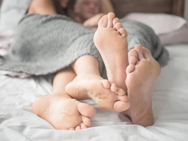 Beskuren bild av pojkvän och flickvän i sängen under täcket — Stockfoto