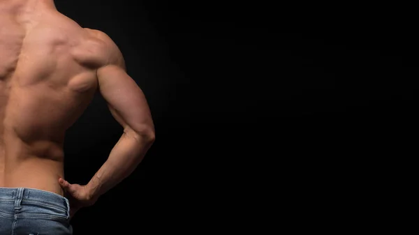 Bakifrån av torsoen av attraktiva manliga kroppen builder på mörk bakgrund. — Stockfoto