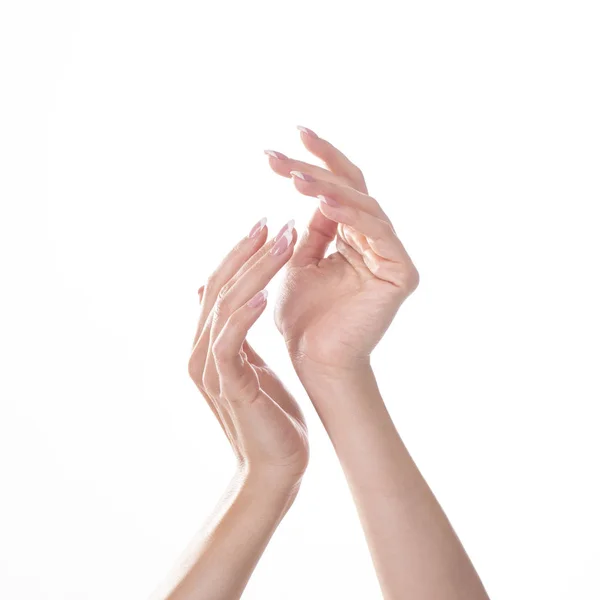 Молодая женщина прикасается к руке и чувствует увлажняющий эффект крема на белом фоне — стоковое фото
