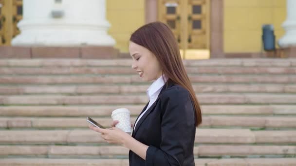 Giovane donna con smartphone a piedi in città, colpo steadicam — Video Stock