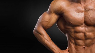 Atletik bir adam. Mükemmel bir abs ile Close-up su bırakır. koyu arka plan.