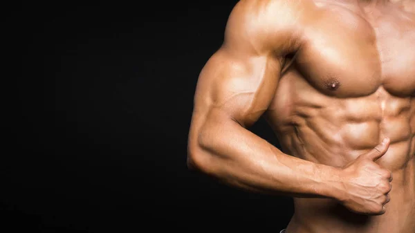 Starker athletischer Mann Fitness-Modell Oberkörper zeigt Sixpack Bauchmuskeln. isoliert auf schwarzem Hintergrund — Stockfoto