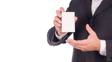 Siyah elbiseli bir kart beyaz arka plan üzerinde tutan bir işadamı