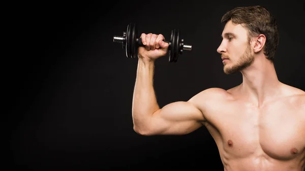 Selbstbewusster junger Mann beim Porträttraining mit Stummglocke vor schwarzem Hintergrund. — Stockfoto