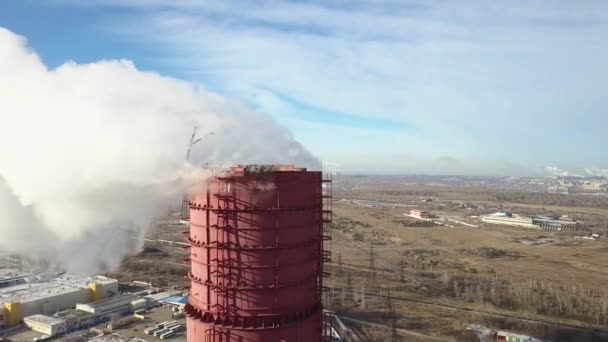 Strefa przemysłowa z dużą rurą czerwono-białą Gruby biały dym jest wylewany z rury fabrycznej w przeciwieństwie do słońca. Zanieczyszczenie środowisko: rura z dym. Widok z lotu ptaka — Wideo stockowe