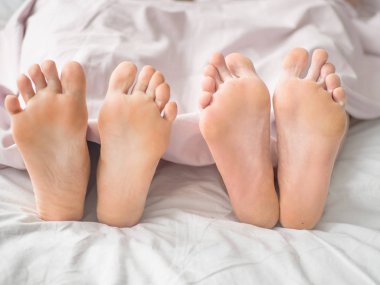 Bir çift yatakta ayak kapatın. Seven çift yatakta battaniyenin altında yalan söylüyor