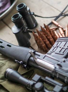 Keskin nişancı tüfeği, dürbün ve ahşap zemin üzerinde mühimmat