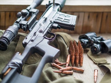 Keskin nişancı tüfeği, bunoculars ve cephane üzerinde ahşap zemin döşeme.