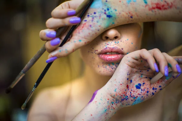 Portret van de kunstenaar vrouw met een druppels van verf op haar gezicht — Stockfoto