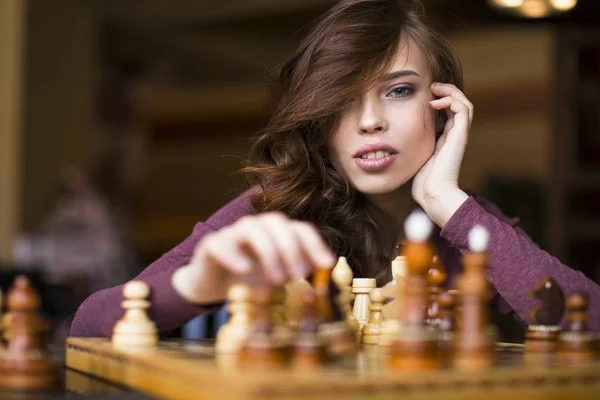 Genç akıllı beyaz kadın evde satranç akıllı rahat kıyafetler giymiş — Stok fotoğraf