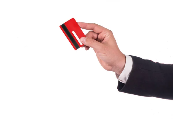 Empresários com cartão de crédito. Mão em terno preto segura um cartão de crédito vermelho em branco. Fecha. Cores do ano novo . — Fotografia de Stock