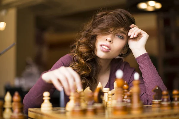 Piękna Brunetka kobieta gra w szachy. Widok z bliska. — Zdjęcie stockowe