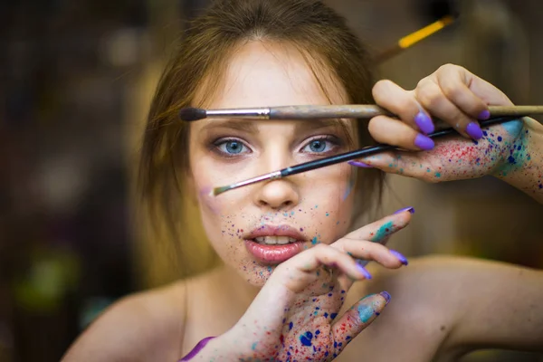 Retrato de mulher artista com uma gota de tintas em seu rosto — Fotografia de Stock