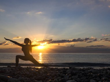 Gün batımında Yoga fitness egzersiz sahilde pratik sağlıklı kadın. Sağlıklı yaşam konsepti. Alan metni kopyalayın.