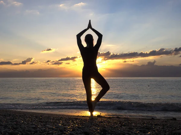 Jeune femme en bonne santé pratiquant le yoga exercice de fitness sur la plage au coucher du soleil. Concept de mode de vie sain. Copier le texte espace . — Photo