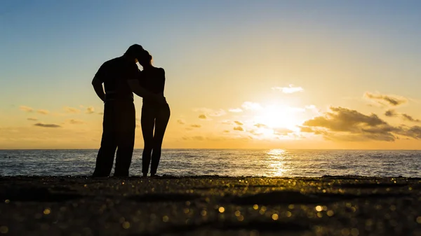 Σιλουέτα του αγάπη ζευγάρι στέκεται δίπλα στο ποτάμι και όμορφο ηλιοβασίλεμα φόντο. — Φωτογραφία Αρχείου