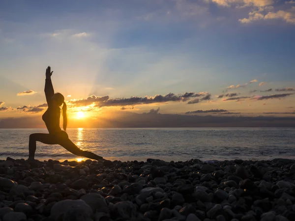 Mujer joven y saludable que practica ejercicio de yoga en la playa al atardecer. Concepto de estilo de vida saludable. Copiar espacio de texto . — Foto de Stock