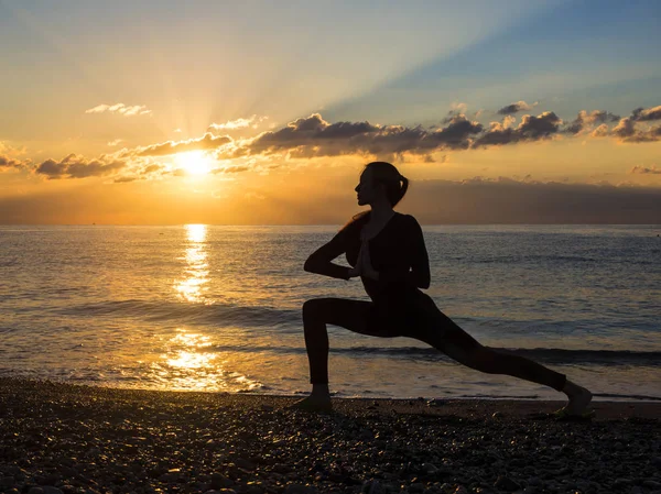 Mujer joven y saludable que practica ejercicio de yoga en la playa al atardecer. Concepto de estilo de vida saludable. Copiar espacio de texto . — Foto de Stock