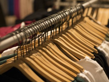 Giysiler tasarımcı giyim mağazasının rafında asılı.