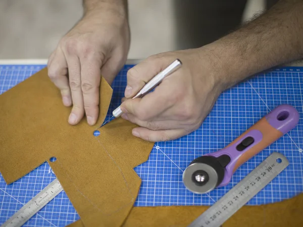 Close up van een schoenmaker snijden leer in een workshop. Handmade en ambachtelijke concept. — Stockfoto