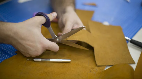 Man aan het werk met leer met behulp van crafting tools. Close-up van mannetjes handen snijden van leder — Stockfoto