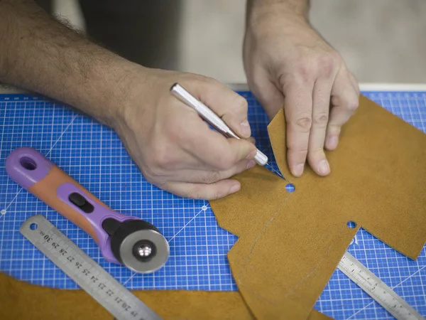 Homem trabalhando com couro usando ferramentas de artesanato. Close-up vista de homens mãos cortando couro — Fotografia de Stock