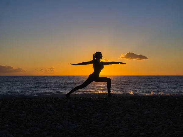 Mode de vie sain fond, silhouette de la femme prcticing yoga sur la plage au lever du soleil — Photo