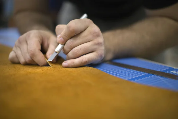 Close up van een schoenmaker snijden leer in een workshop. Handmade en ambachtelijke concept. — Stockfoto